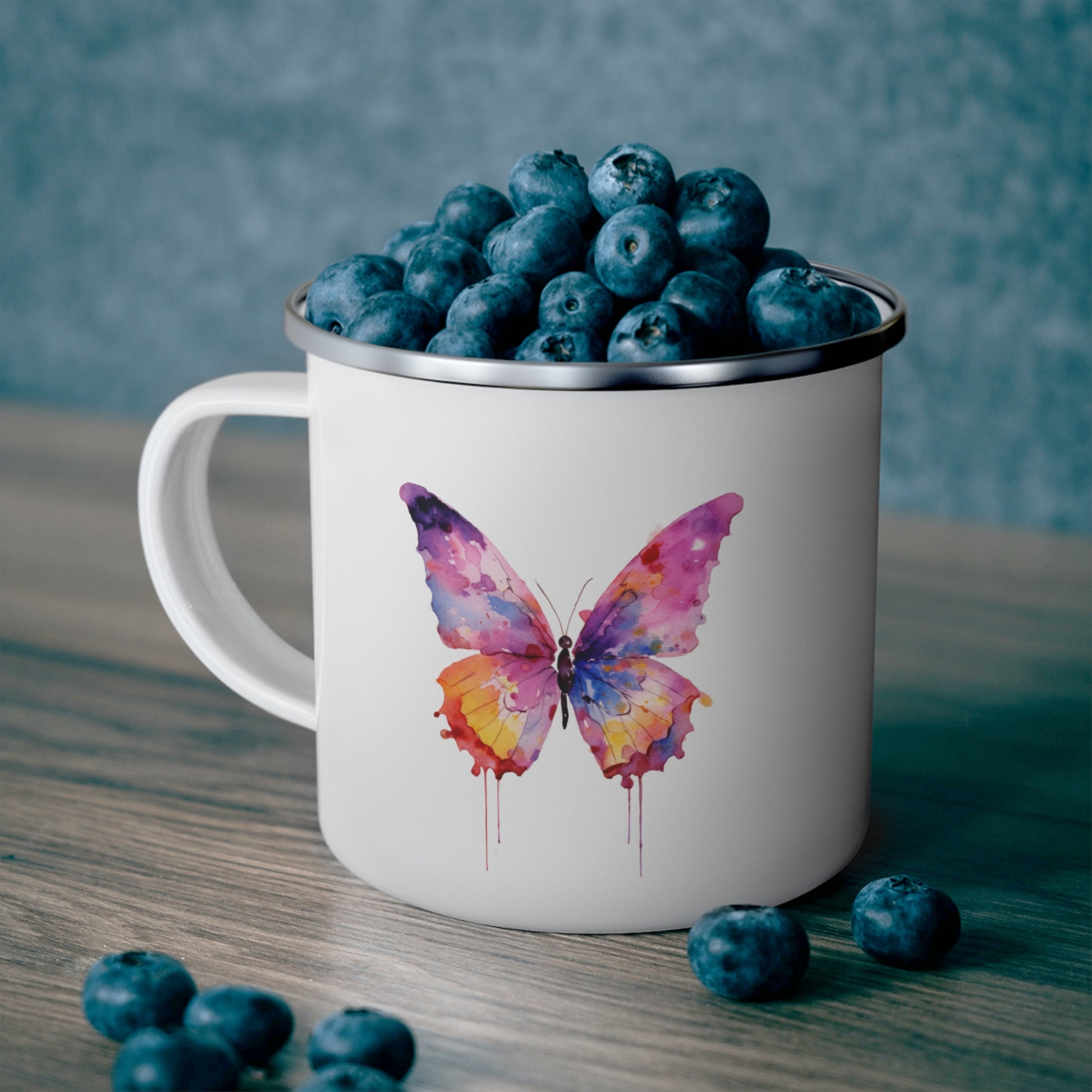 butterfly camping mug holding blueberries
